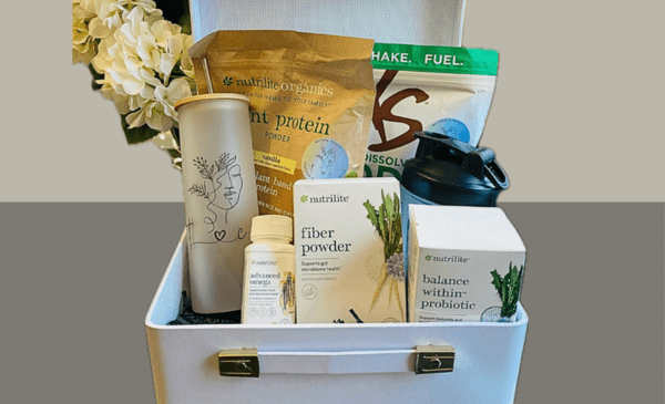 A customized gift basket showcasing a mix of health products like organic plant-based protein, Balance Within probiotic, fiber powder, liver support supplement & a shaker bottle. Gourmet gift baskets. Fun gift idea.